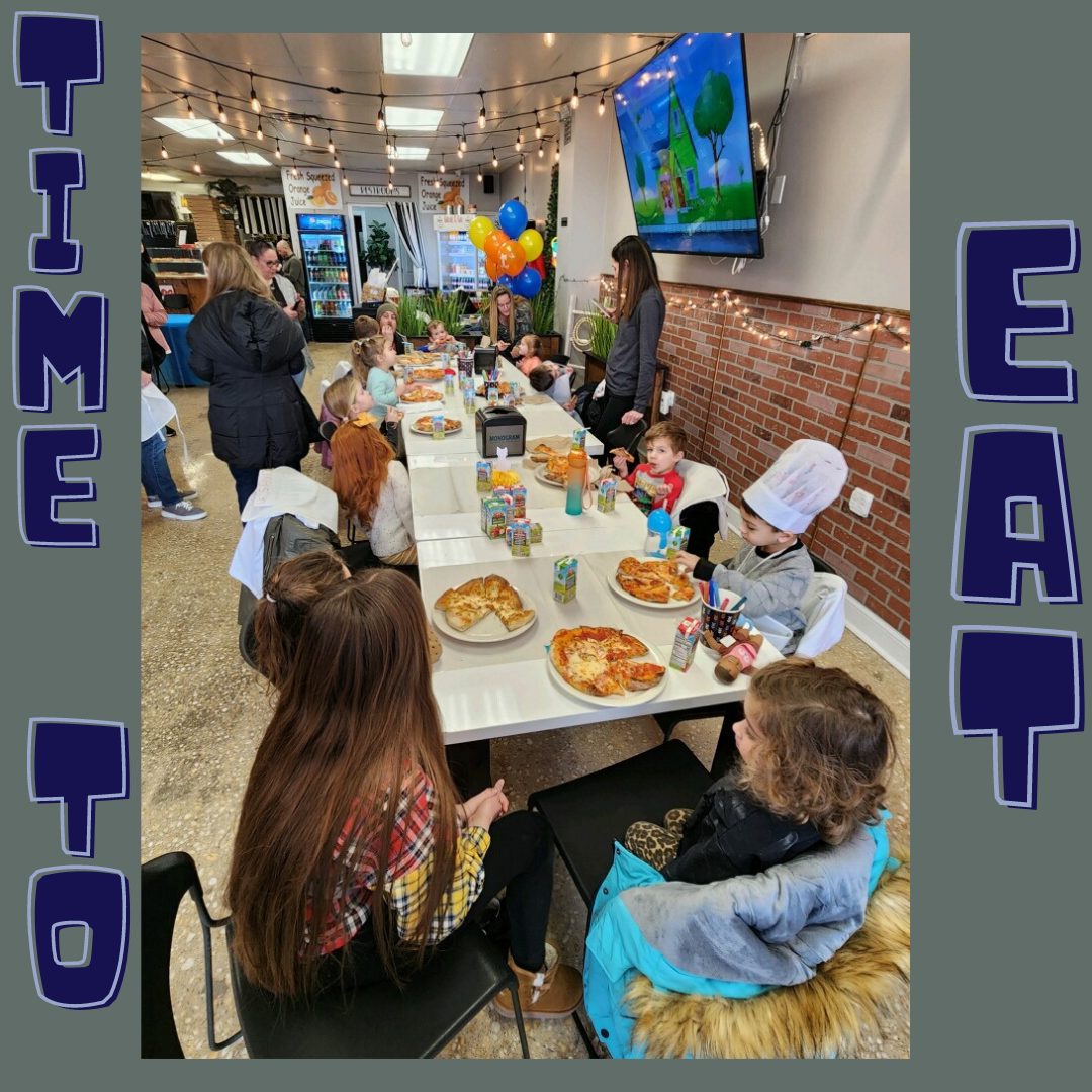 Party guests seated at a long table eating the personal pizzas they made at Gigi's
